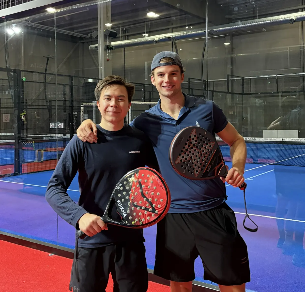 To spillere med rackets som smiler til kameraet